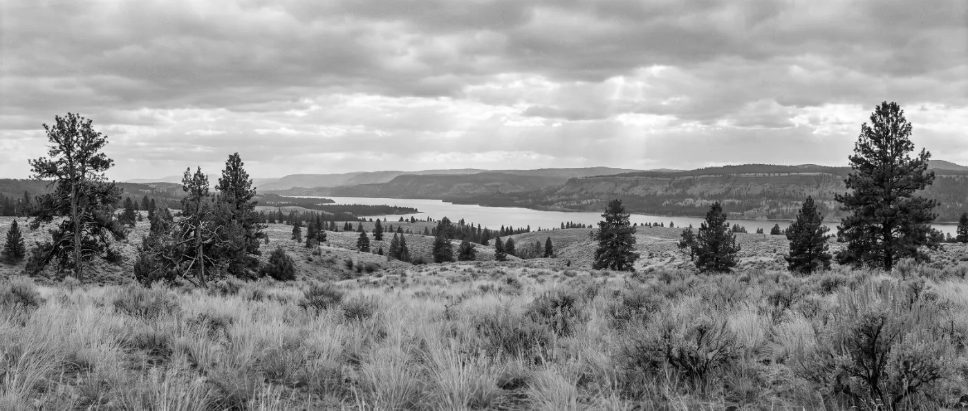 The Cariboo plateau: bunchgrass rangeland, a long lake, forested ridges beyond
