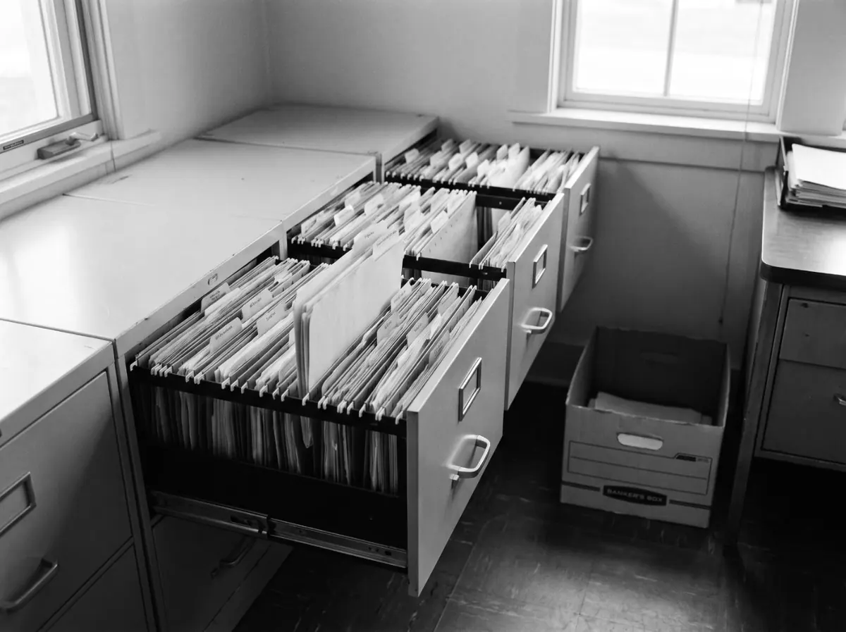 Open filing cabinet drawers dense with manila folders