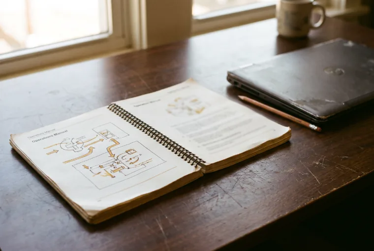 A printed operations manual open on a desk